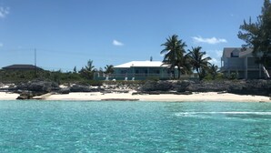 A beachfront property with a clear view of the ocean, a sandy beach, and a house with a balcony overlooking the sea. - The nicest beach house in Great Harbour,   Guaranteed!   Enjoy🏝 (Great Harbour Cay, Bahamas (GHC))