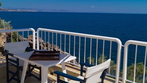 Una terraza con una mesa y sillas con vista al agua.