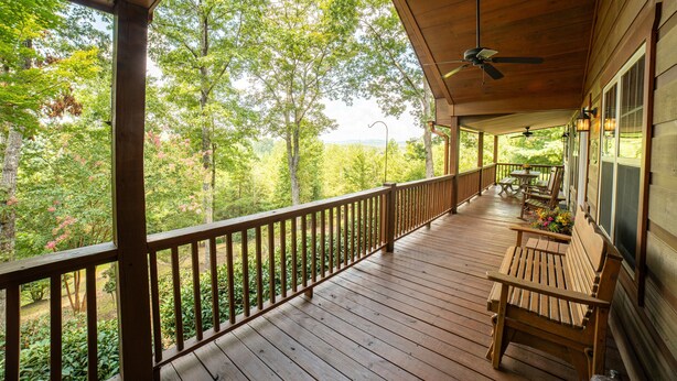 A wooden deck with a railing, a bench, and a table. - Haven in the Hills! Spectacular Views, River Access, & 5-Star Amenities! (Murphy)