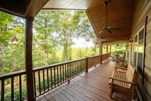 A wooden deck with a railing, a bench, and a table. - Haven in the Hills! Spectacular Views, River Access, & 5-Star Amenities! (Murphy)