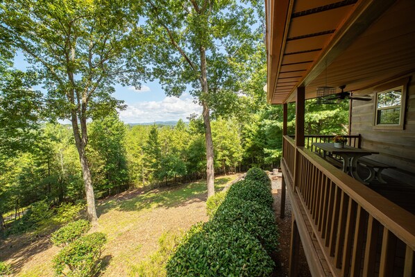 A wooden deck with a view of a forested area. - Haven in the Hills! Spectacular Views, River Access, & 5-Star Amenities! (Murphy)