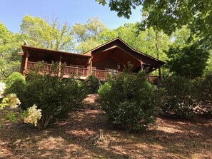 Surrounded by lush greenery, this cabin offers a serene escape with a covered porch and balcony.