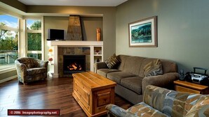 A living room with a fireplace, a sofa, a coffee table, and a television.