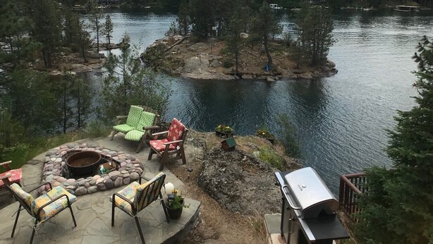 Une terrasse au bord du lac, dotée de sièges extérieurs et d’un foyer.