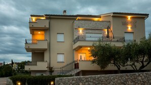 A multi-story building with balconies, a stone facade, and a sign reading "Villa Se".