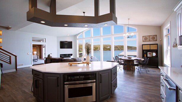 A spacious kitchen with a large island, a dining area with a view of the lake, and a living area with a TV and seating. - Executive Getaway close to all the action with Private 2 slip dock  (Sunrise Beach)