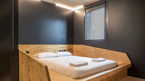 A modern bedroom with a wooden headboard, a large window, and a neatly made bed. - JO&JOE Paris - Gentilly Hotel - Hostel (Gentilly)