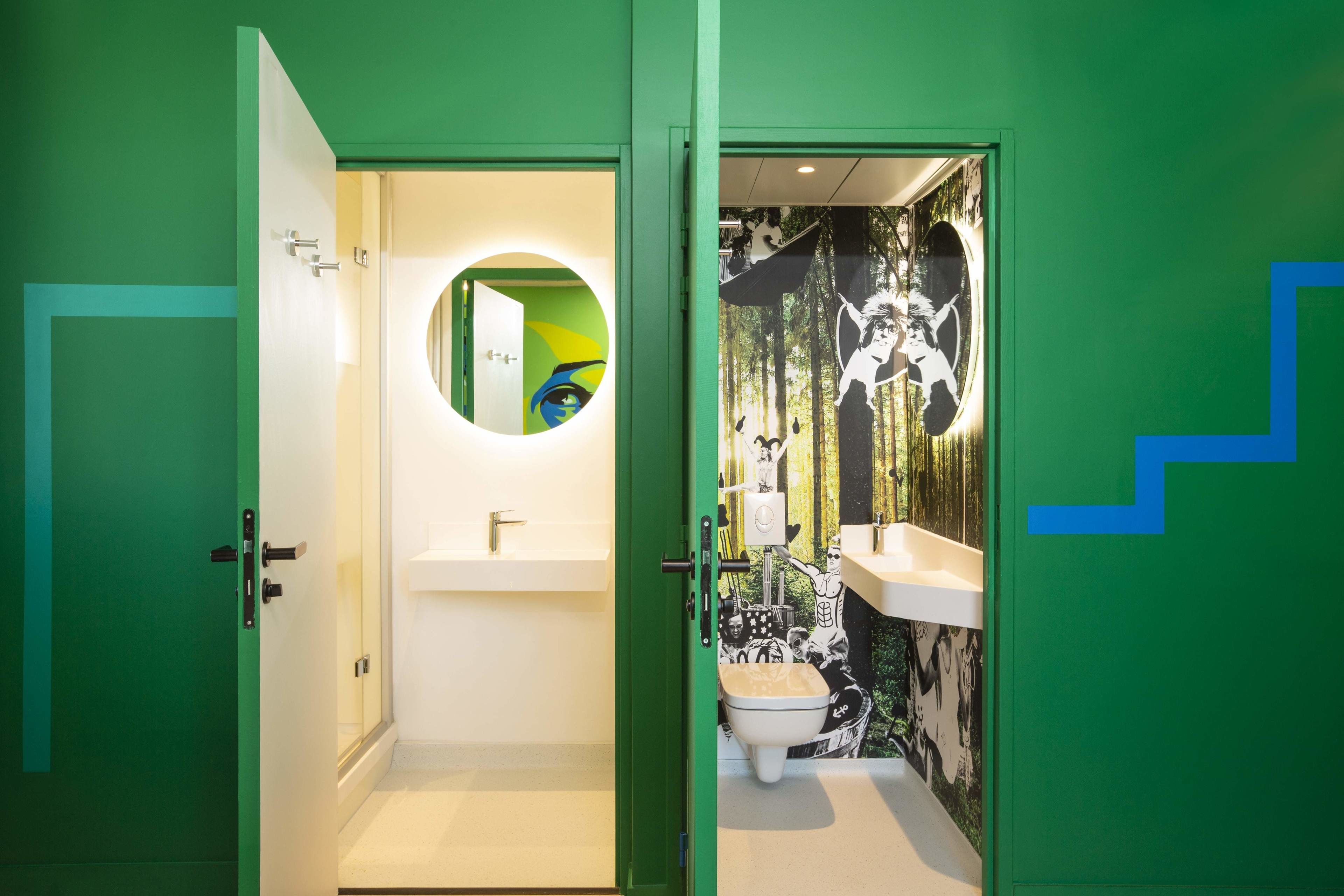 A bathroom with a green door, a white sink, and a toilet.
