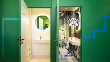 A bathroom with a green door, a white sink, and a toilet.