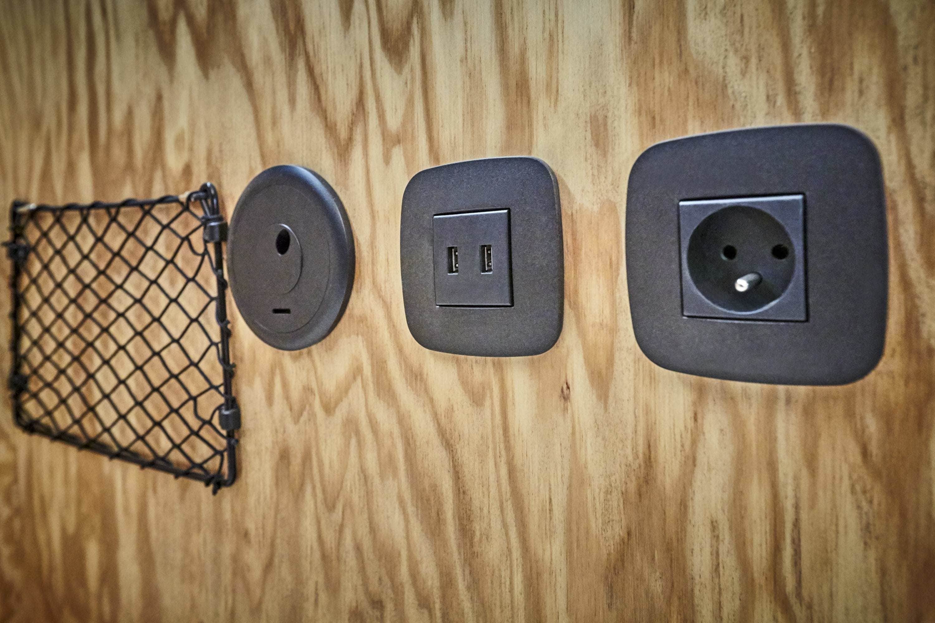 Een houten wand met drie stopcontacten en een stekkerdoos.