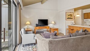 A living room with a sofa, a television, a coffee station, and a dining area. - Sanctuary at Sundendorf- New Updates! (Bellaire)
