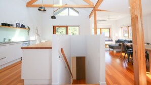 Une cuisine moderne avec des armoires blanches, un plan de travail en bois et des luminaires suspendus.
