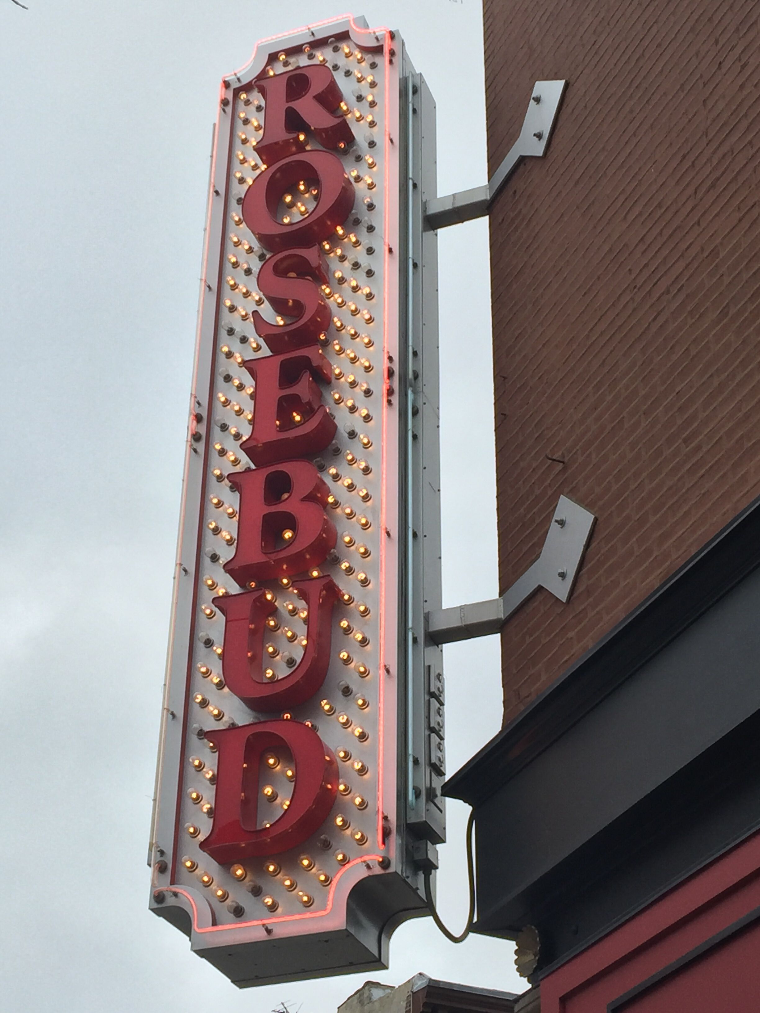 Un letrero de neón con la palabra "ROSEBUD" en un edificio.