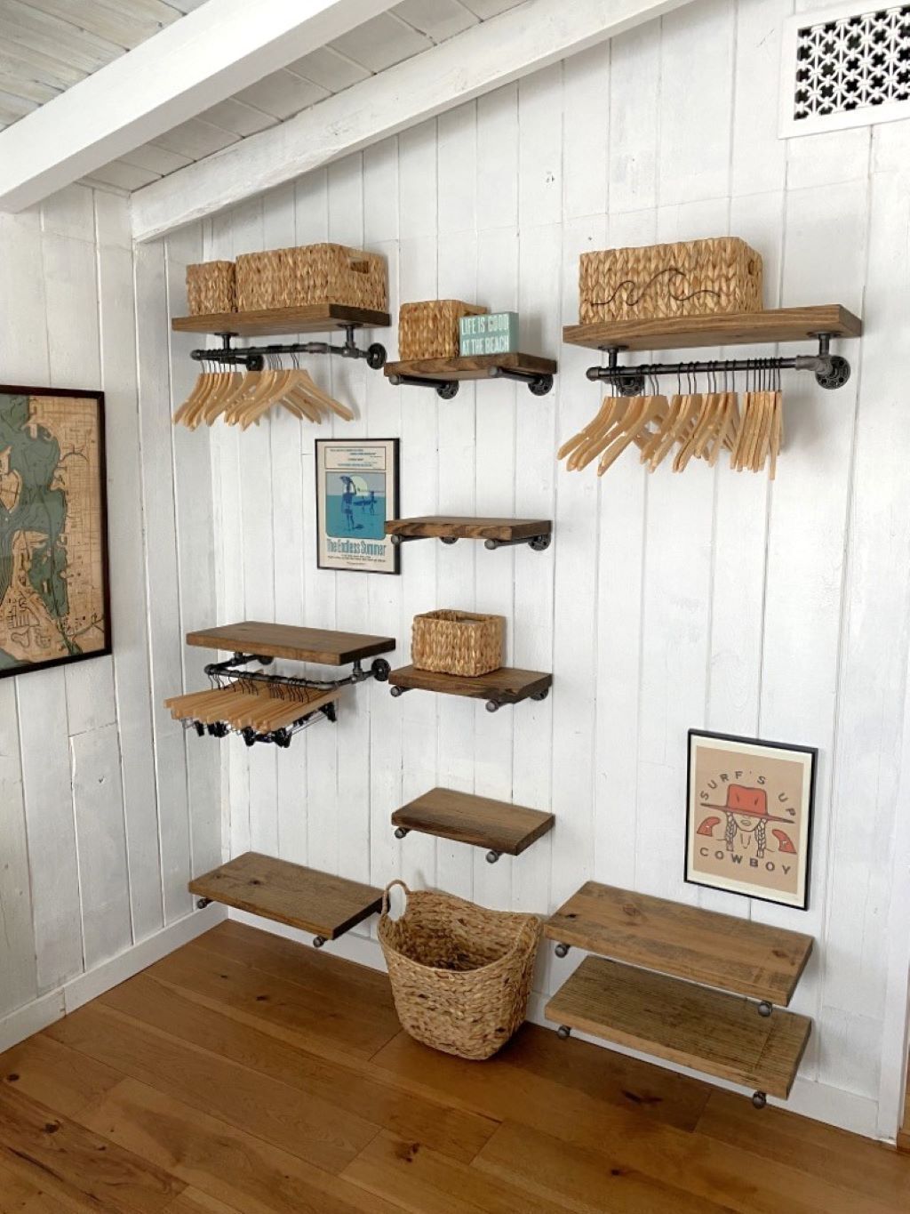 A wall with multiple wooden shelves and hooks, some holding baskets and a framed picture.