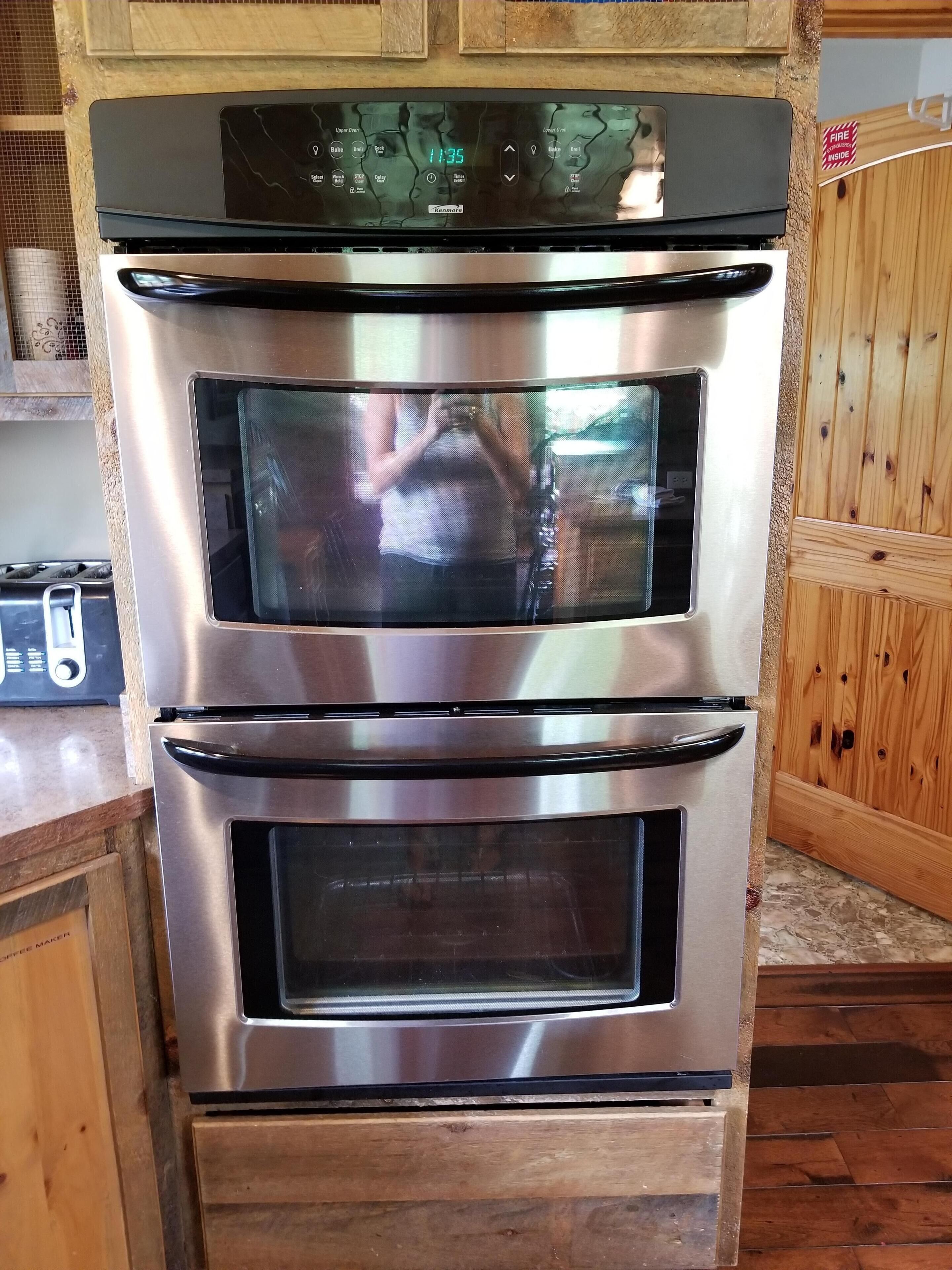 A stainless steel double oven with a digital display and a control panel.