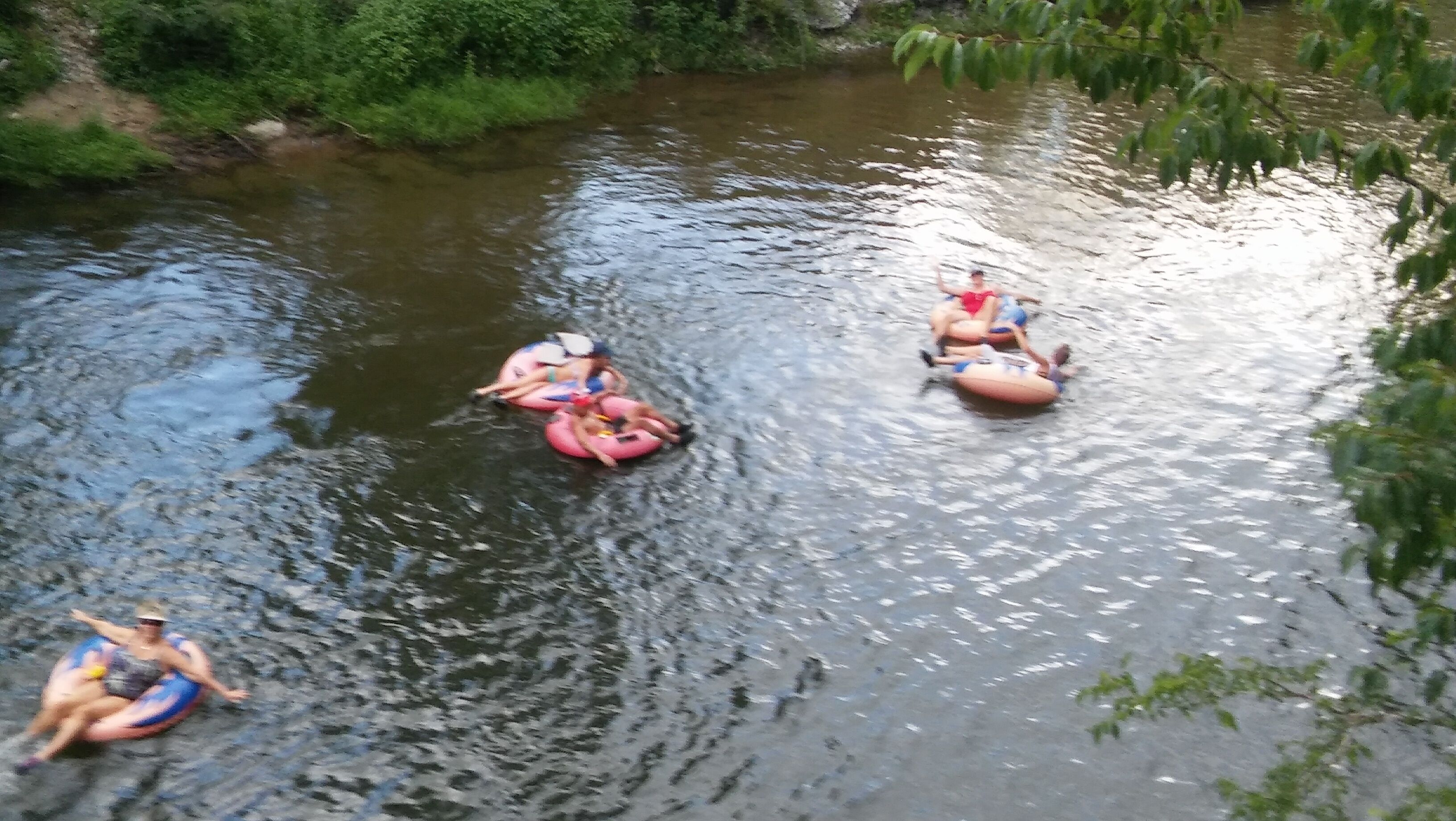 Mensen drijven in opblaasbanden op een rivier.