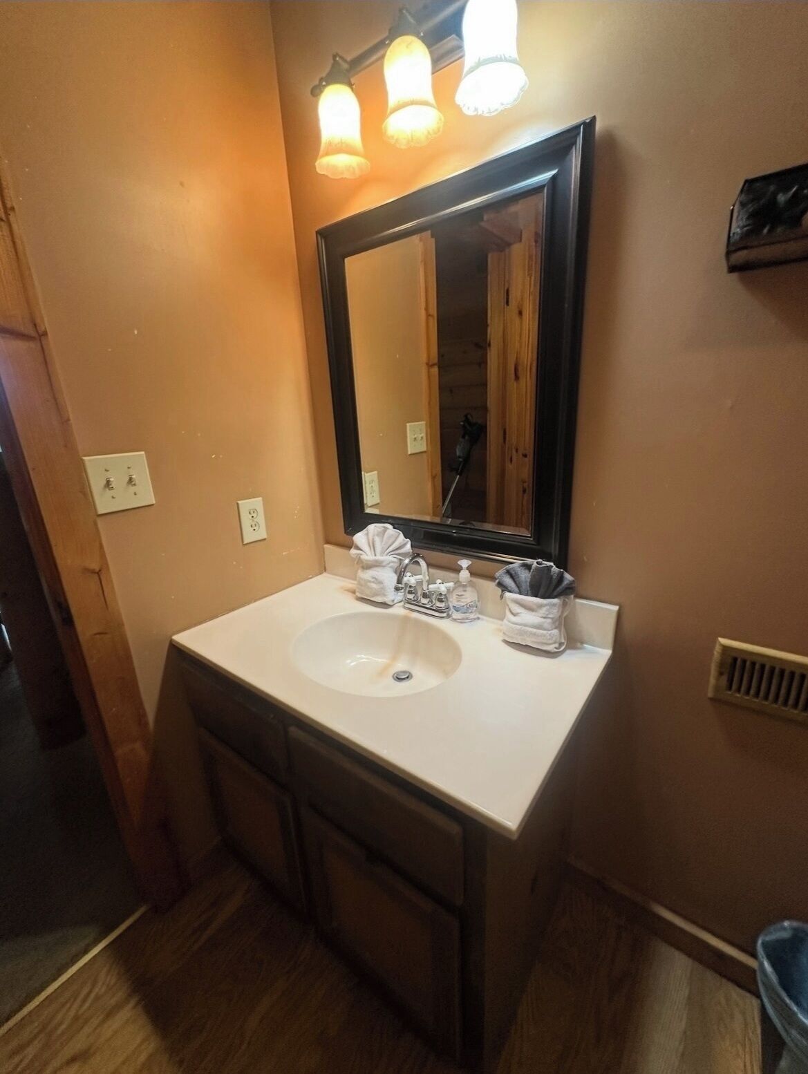 Une salle de bain avec un lavabo blanc, un miroir et un porte-serviettes.