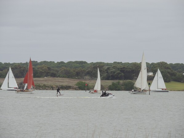 A body of water with several sailboats and a jet ski. - PS Federal romantic retreat (Goolwa)