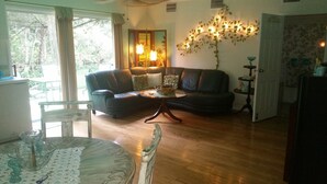 Ein Wohnzimmer mit einer Couch, einem Couchtisch und einem Esstisch mit Stühlen.
