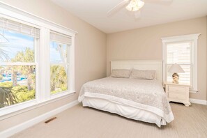 Quarto com uma cama, mesa de cabeceira, abajur e janela com persianas.