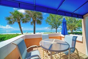 Un espace extérieur abrité, aménagé avec des sièges, et offrant une vue sur la plage et l’océan.