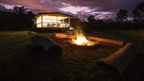 Ein Haus mit Veranda und Feuerstelle im Garten.
