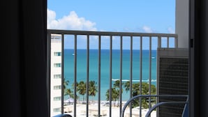 Un balcone con vista sull'oceano e palme.