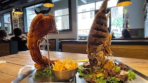 Un ristorante con un tavolo di legno su cui è servito un piatto di pesce e patatine fritte.