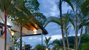 A pathway leading to a covered area with steps, surrounded by tropical plants and palm trees, under a clear sky. - AMAZING Hillside Home, Private Infinity Pool, Covered Veranda, Spacious Rooms (Manuel Antonio)