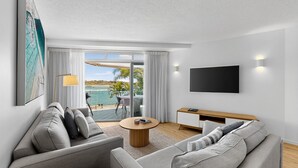 Una sala de estar moderna con un sofá, una mesa de centro y un televisor montado en la pared.