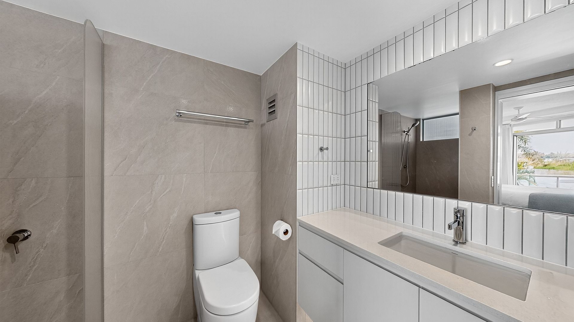 Une salle de bain moderne équipée de toilettes, d’un lavabo et d’une douche.