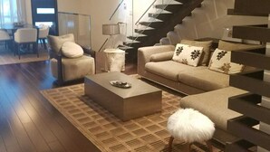 Un salon moderne avec un canapé, une table basse et un escalier.