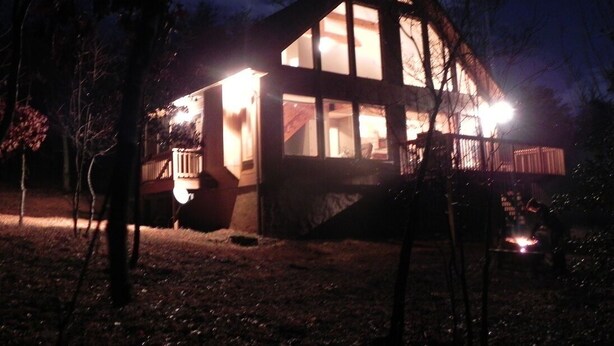 A house with a large glass window, a porch, and a fire pit in the yard. - Unwind with Sautee Start Line, Hot tub, Firepit, Hammock, PS3 (Clarkesville)