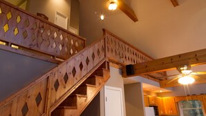 A wooden staircase with a diamond-patterned railing leading to an upper floor. - Unwind with Sautee Start Line, Hot tub, Firepit, Hammock, PS3 (Clarkesville)