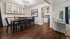A modern kitchen with white cabinetry, a dining table with chairs, and a living area with a sofa. - 2 Living Rooms, Lots of Big Beds! 3 king, 2 queen (Austin)
