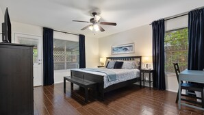 A bedroom with a bed, bedside tables, a desk, a chair, a ceiling fan, and a TV. - 2 Living Rooms, Lots of Big Beds! 3 king, 2 queen (Austin)