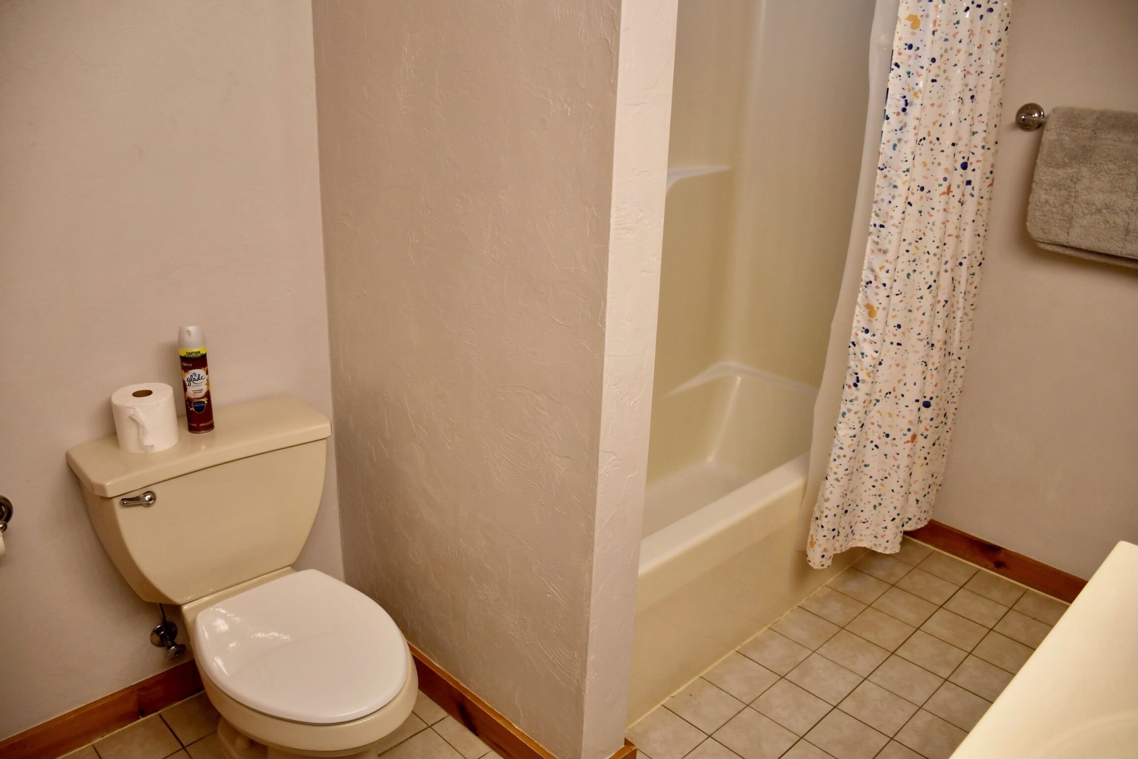 Un baño con inodoro, bañera y cortina de ducha.