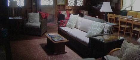 A cozy living room with a sofa, chairs, a coffee table, and a bookshelf.