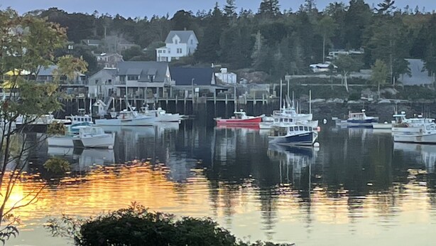 A harbor with boats docked, a large house, and trees in the background. - Upstairs level of two story home (Downstairs is a separate rental) in Bass Hbr. (Bass Harbor)