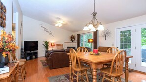 A spacious living room with a wooden dining table, comfortable seating, a flat-screen TV, and a fireplace. - Beautiful Home,Pool Table,Ping Pong, Air Hockey, Foosball, Views   250.00 (Massanutten)