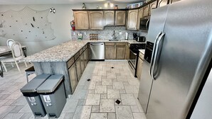 A modern kitchen with granite countertops, stainless steel appliances, and wooden cabinets. - BEACH BLOCK, 100 steps to BOARDWALK and SAND, Sleeps 10 (Wildwood)