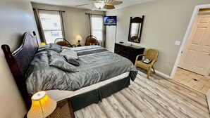 A bedroom with a bed, a dresser, a chair, a ceiling fan, and a TV on the wall. - BEACH BLOCK, 100 steps to BOARDWALK and SAND, Sleeps 10 (Wildwood)
