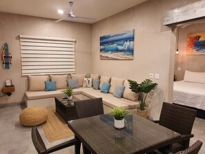 A modern living room with a sofa, a dining table, and a ceiling fan. - Vista Tortuga - VILLA ARENA Heated Pool by the BEACH (Todos Santos)