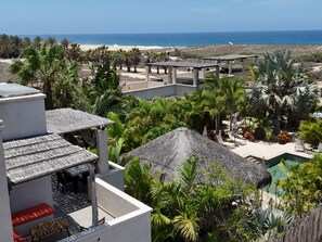Resort com piscina, área de estar ao ar livre e vista para a praia.