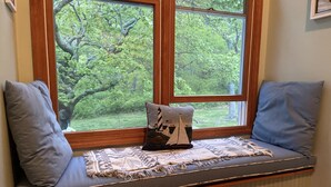 A window seat with two cushions, a decorative pillow, and a woven mat. - Waterfront, beautiful home, breathless sunsets on Prudence Island (Prudence Island)