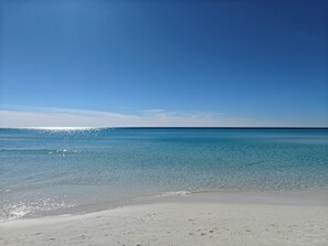 Una playa con agua azul cristalina y una orilla arenosa.