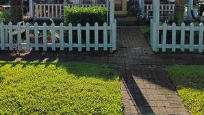 Ein Haus mit Veranda, einem Schild mit der Aufschrift 'Welcome Friends' und einer Palme.