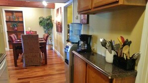 Una cocina con armarios de madera, cafetera y dispensador de agua.
