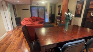Comedor con mesa de madera, sillas y un florero.
