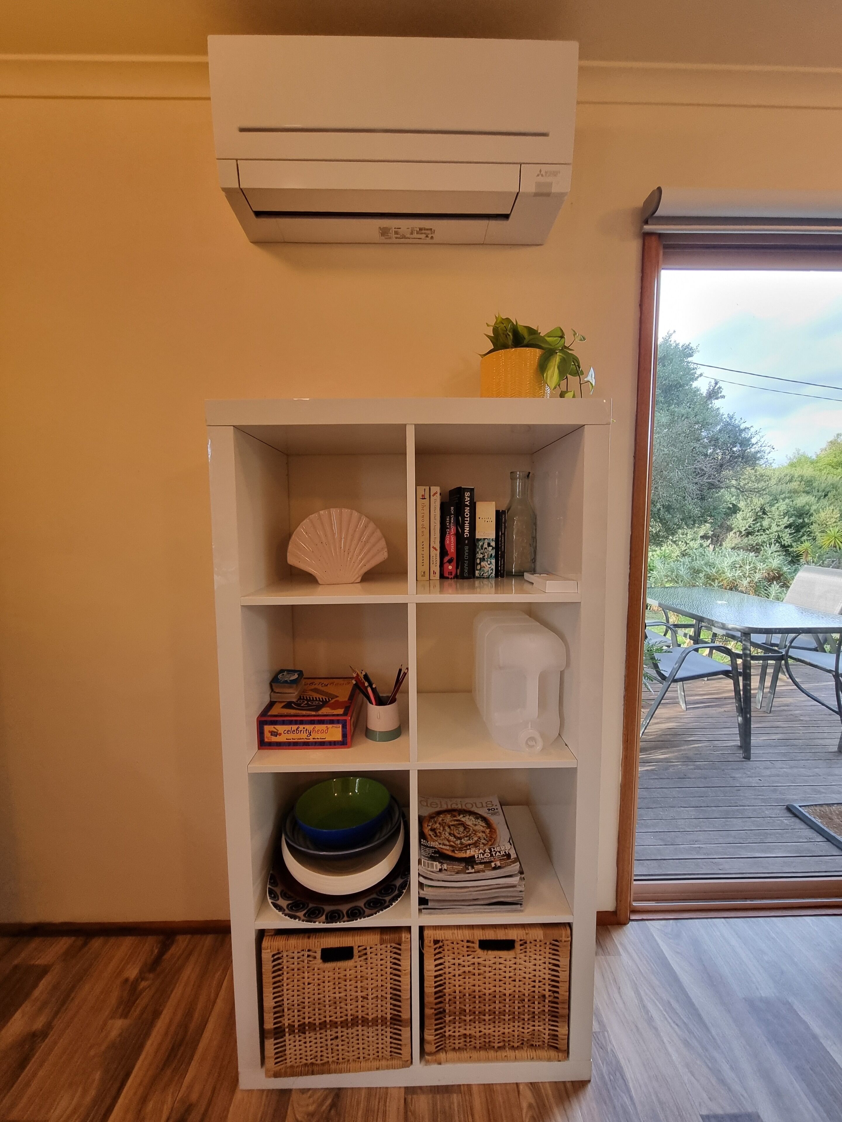 A white bookshelf with various items including books, a fan, and decorative objects.